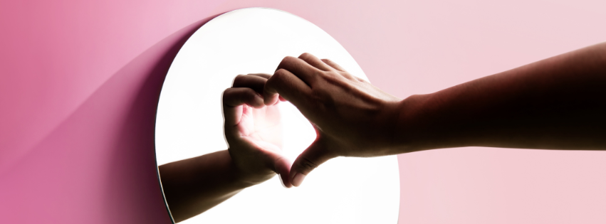 Hand formt Herz vor Spiegel – Symbol für Selbstwahrnehmung und psychosomatische Heilung durch Hypnose in Leipzig